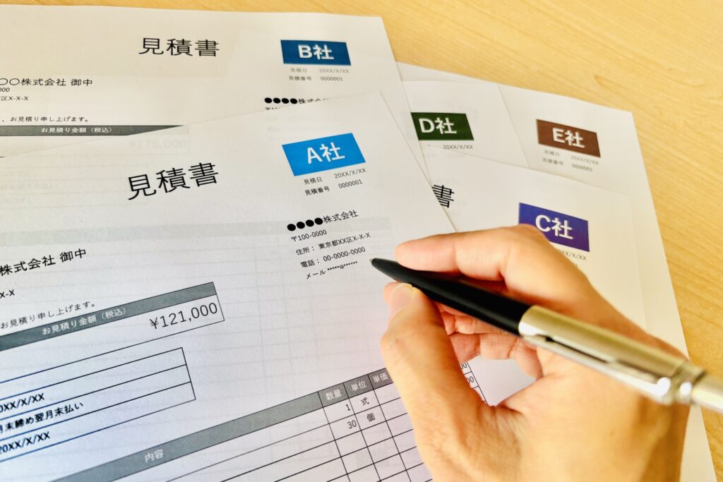 複数社の見積書を並べて比較検討している様子