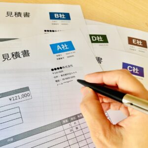 複数社の見積書を並べて比較検討している様子