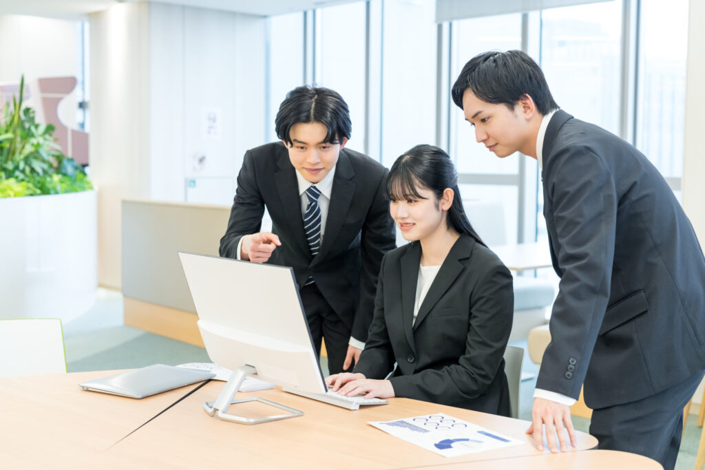 ノートPCの画面を3人で確認しながら商談の設計を詰める営業チーム