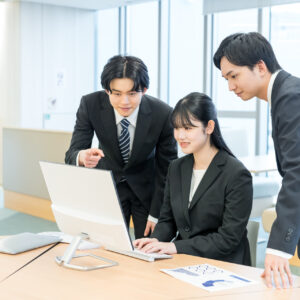 ノートPCの画面を3人で確認しながら商談の設計を詰める営業チーム