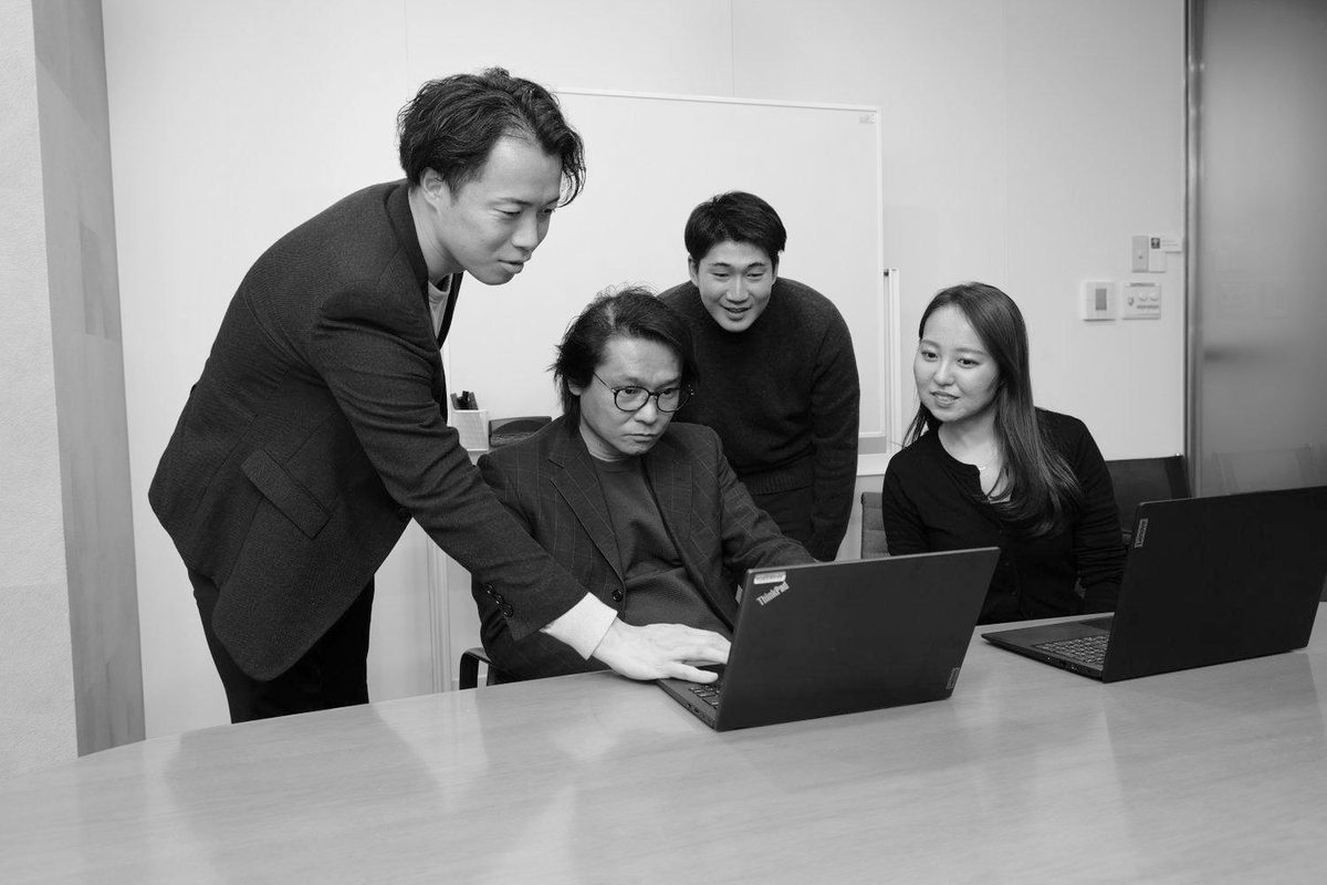 メンバーが1台のPCを囲んで議論する様子